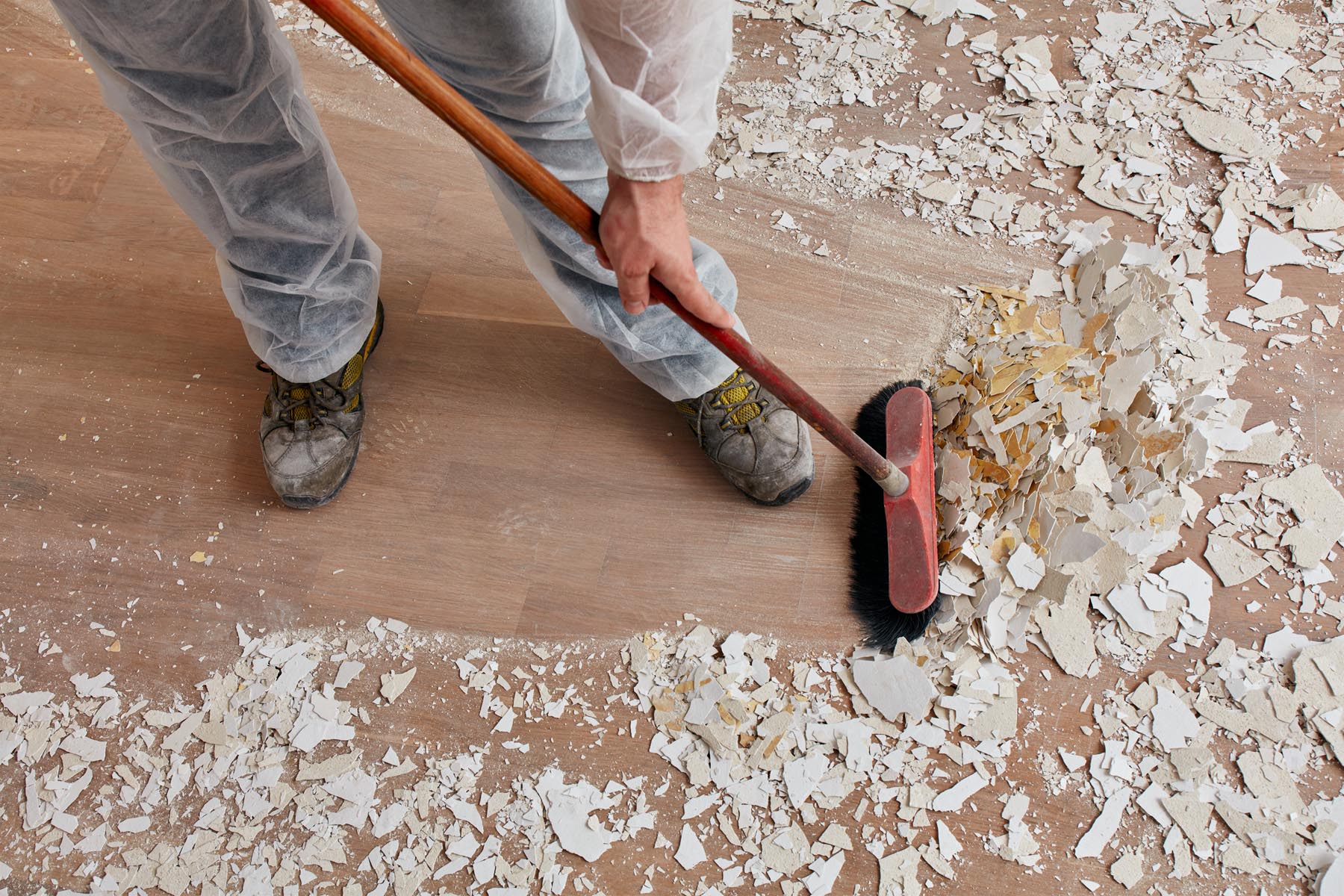 Builder sweeping the floor after renovation