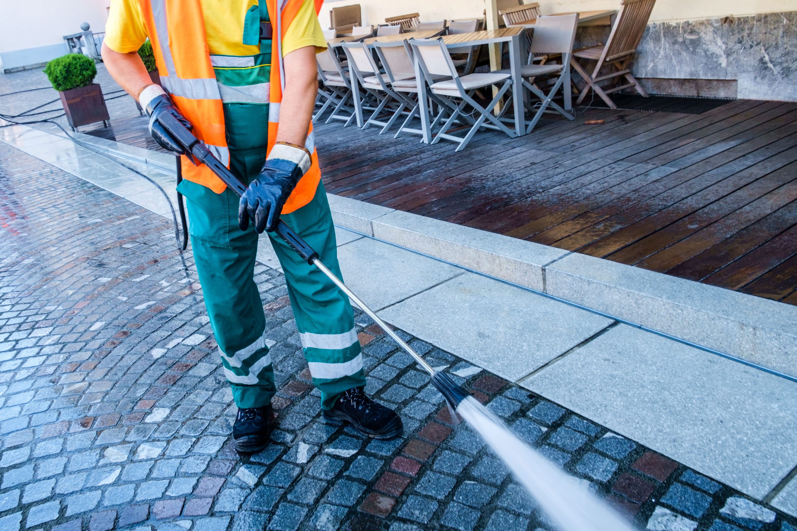 construction worker powerwashing the street