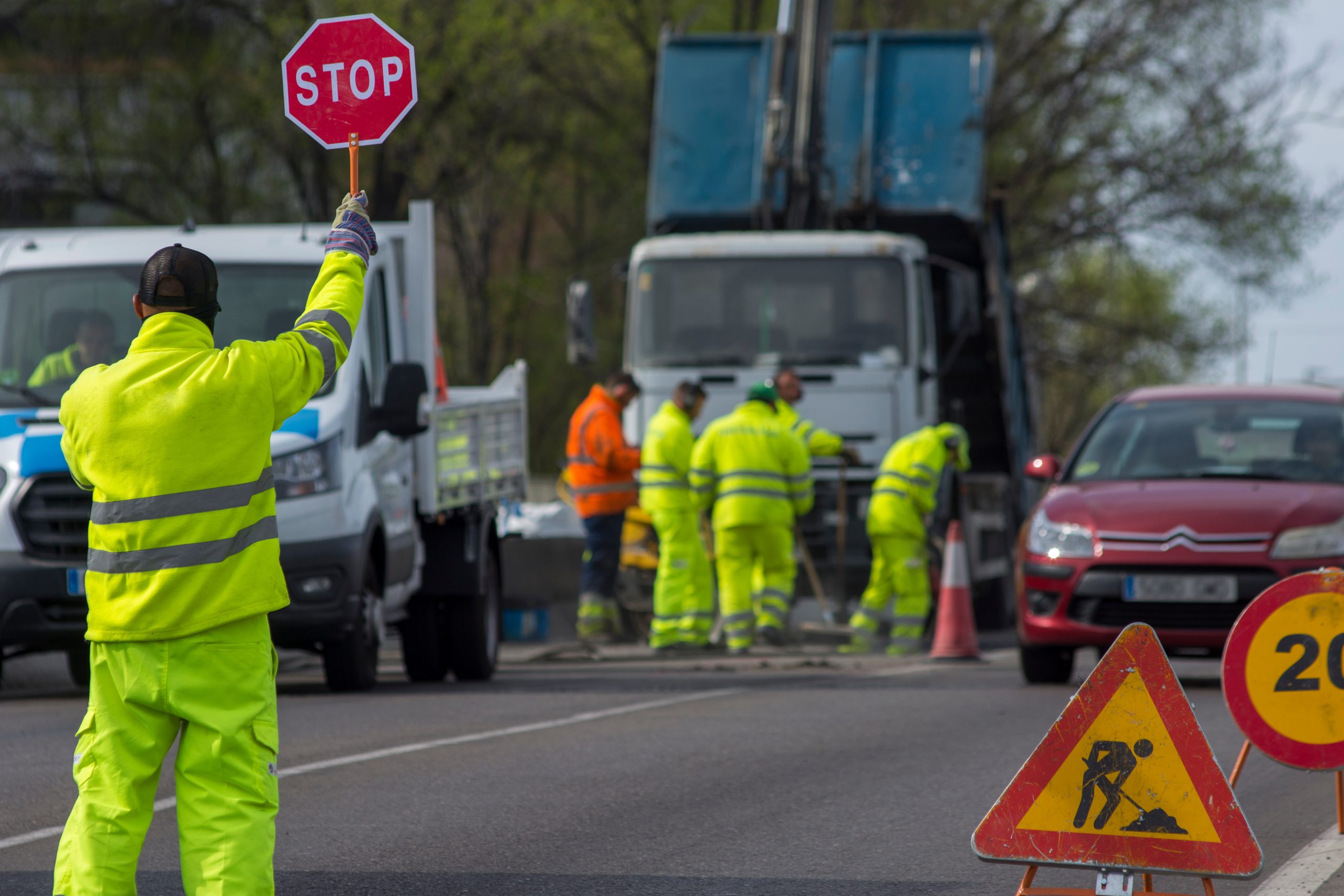 A group of construction workers are working on a road.